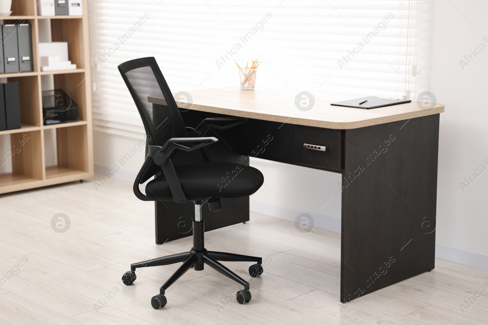 Photo of Black chair and wooden desk in office