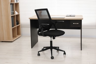 Photo of Black chair, laptop and desk in office