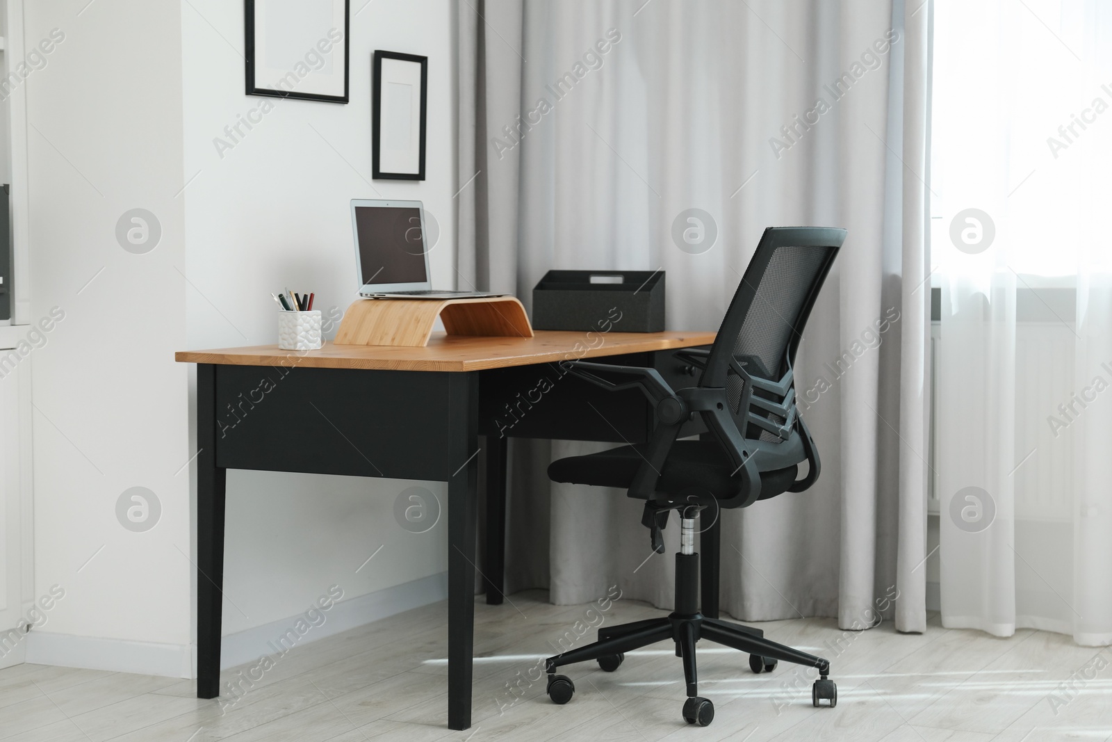 Photo of Black chair, laptop and desk in office