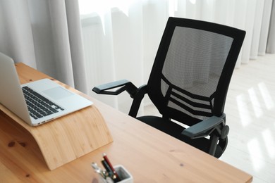 Photo of Black chair, laptop and desk in office