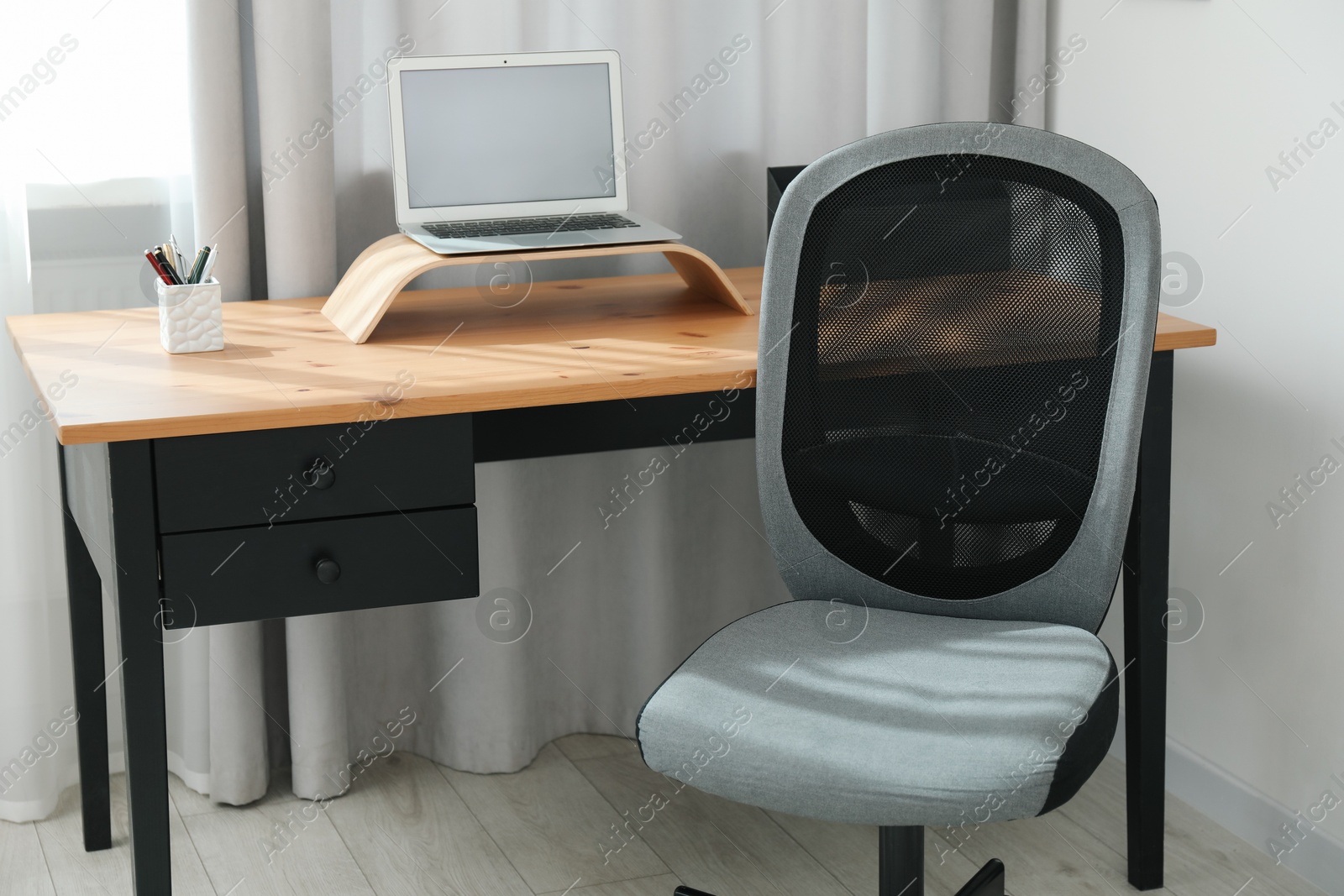 Photo of Grey chair, laptop and desk in office