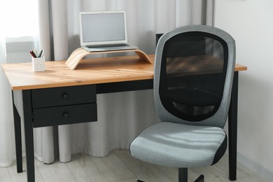 Grey chair, laptop and desk in office