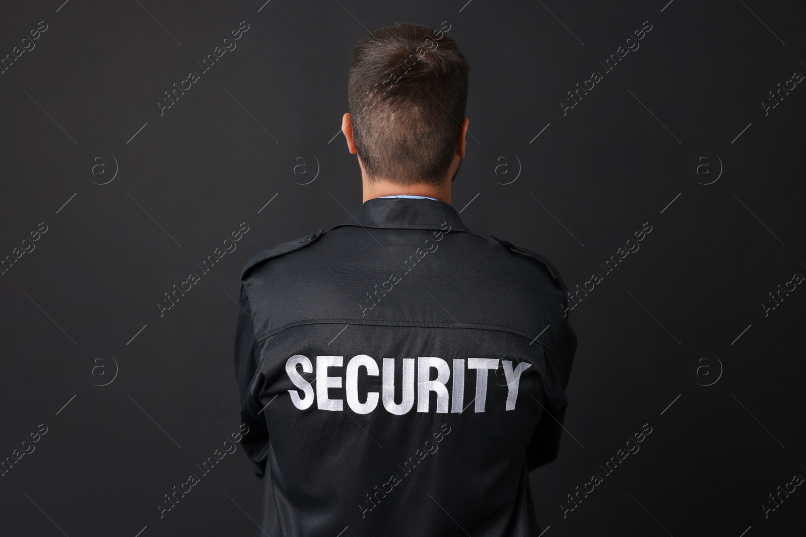 Photo of Security guard in uniform on black background, back view