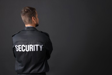 Photo of Security guard in uniform on black background, back view. Space for text