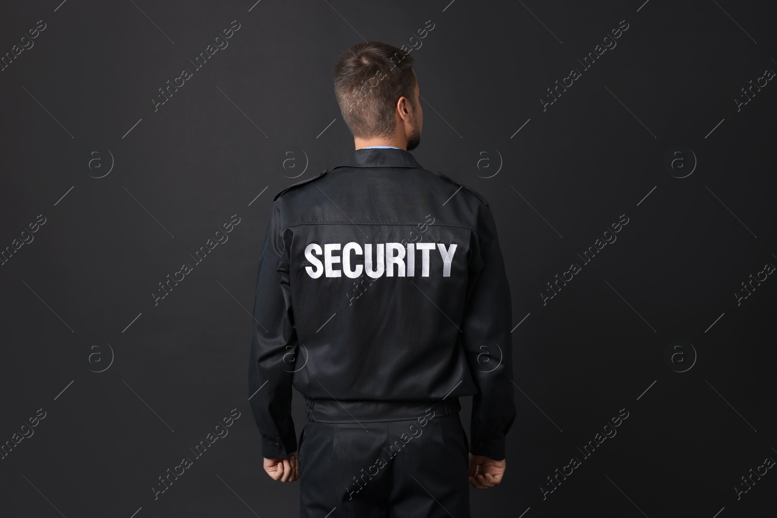 Photo of Security guard in uniform on black background, back view