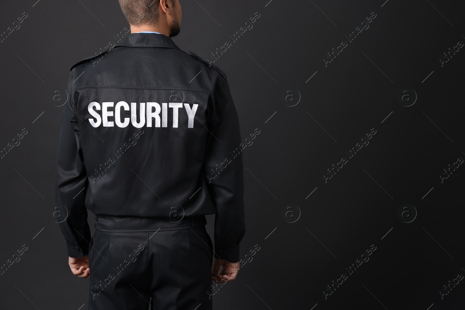 Photo of Security guard in uniform on black background, closeup. Space for text