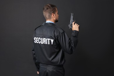 Security guard in uniform with gun on black background