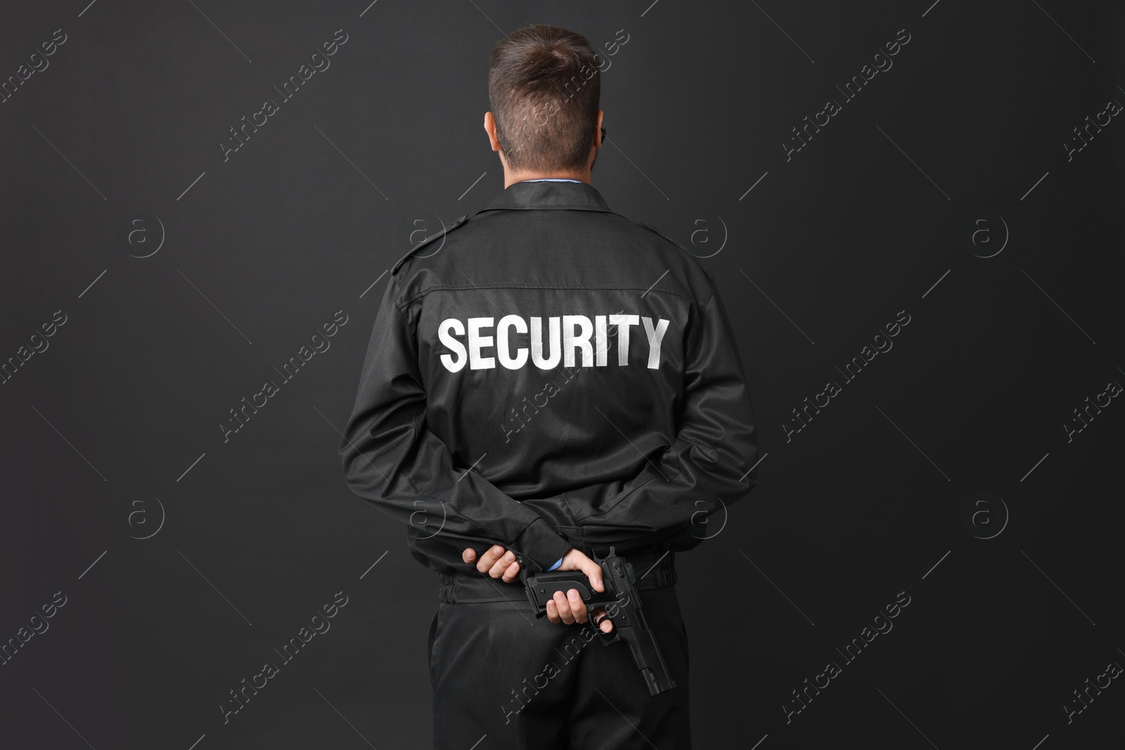 Photo of Security guard in uniform with gun on black background, back view