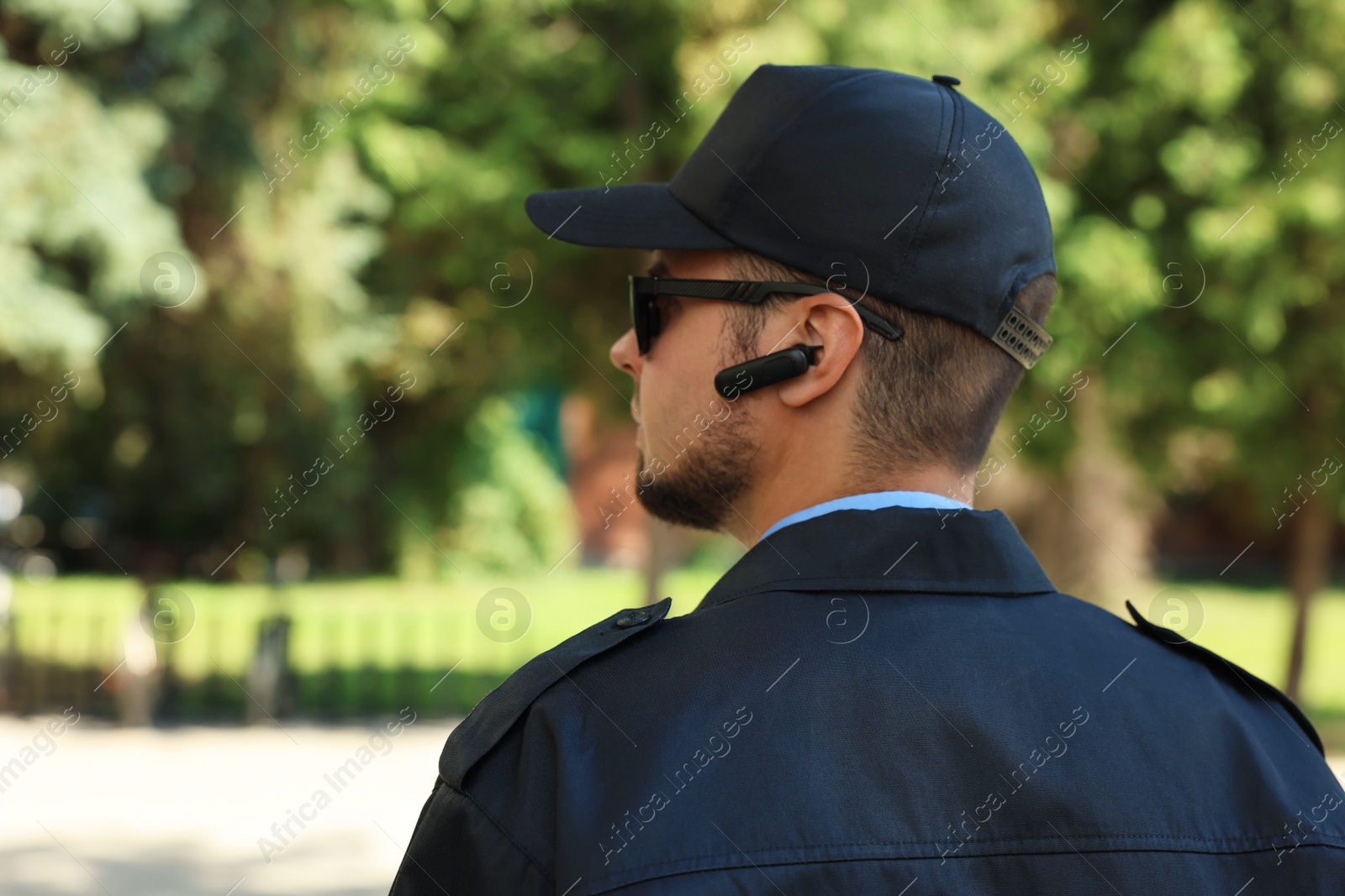 Photo of Security guard in uniform and sunglasses outdoors