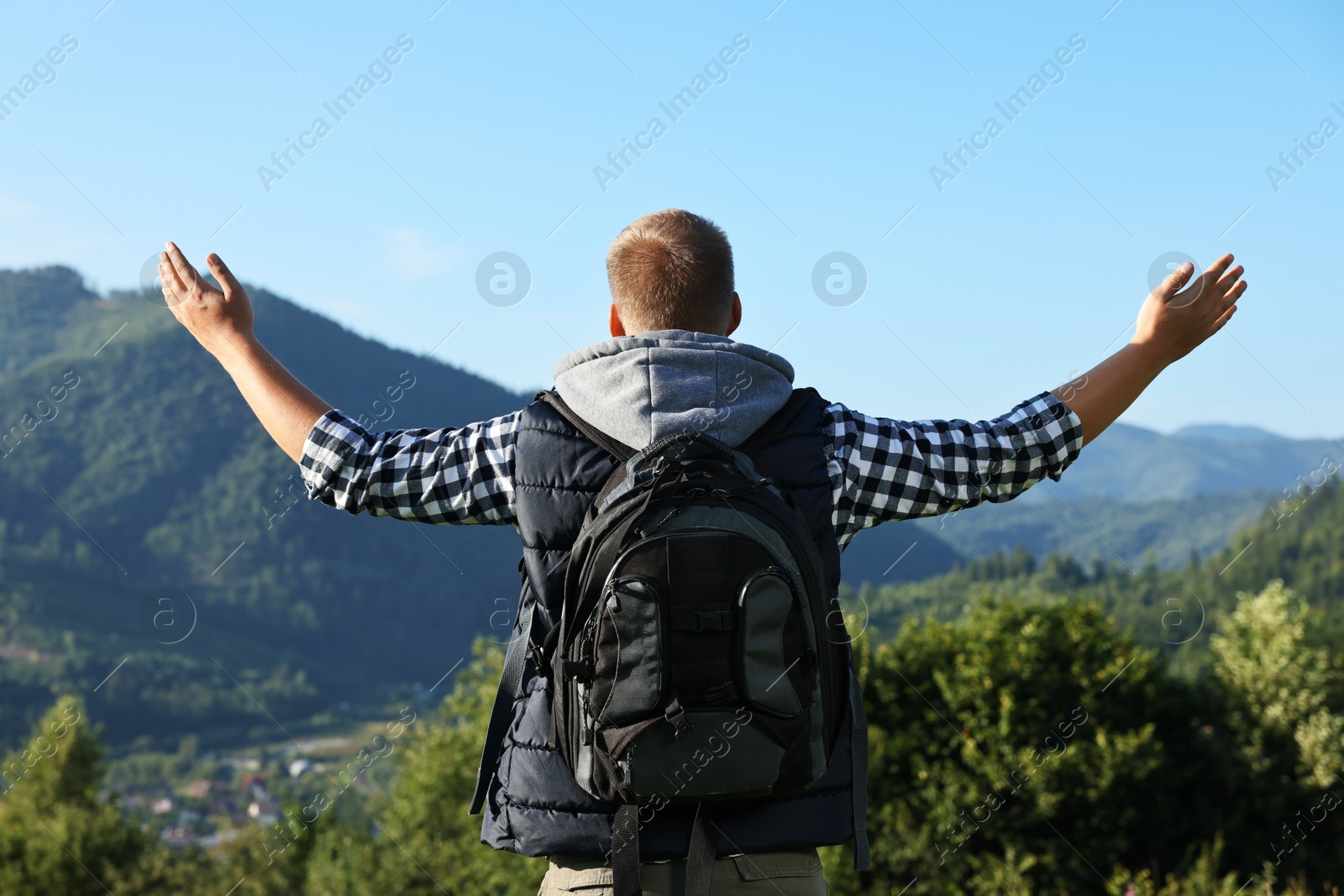 Photo of Man with backpack in beautiful mountains, back view