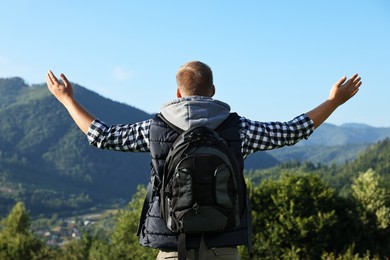 Man with backpack in beautiful mountains, back view