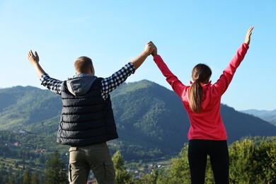 Couple in beautiful mountains on sunny day, back view