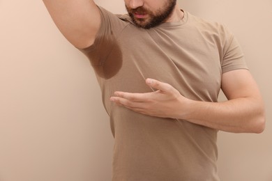 Photo of Man before using deodorant on beige background, closeup