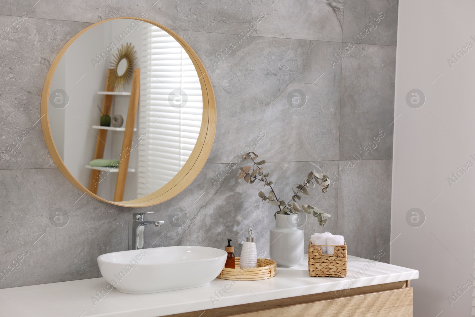 Photo of Bath accessories, eucalyptus branches, sink and mirror in bathroom