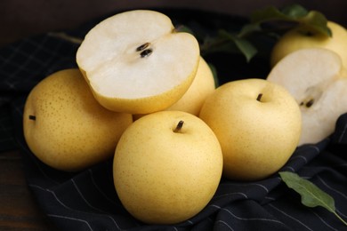 Photo of Delicious fresh apple pears and green leaves on table, closeup