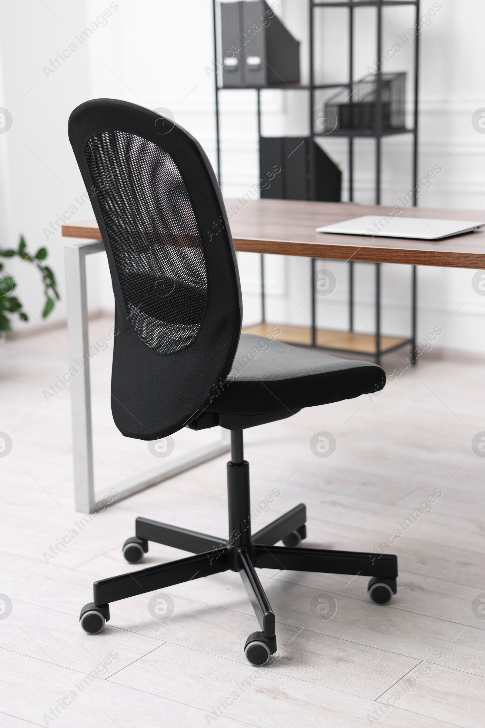 Photo of Black chair, laptop and desk in office