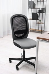 Photo of Black chair and wooden desk in office