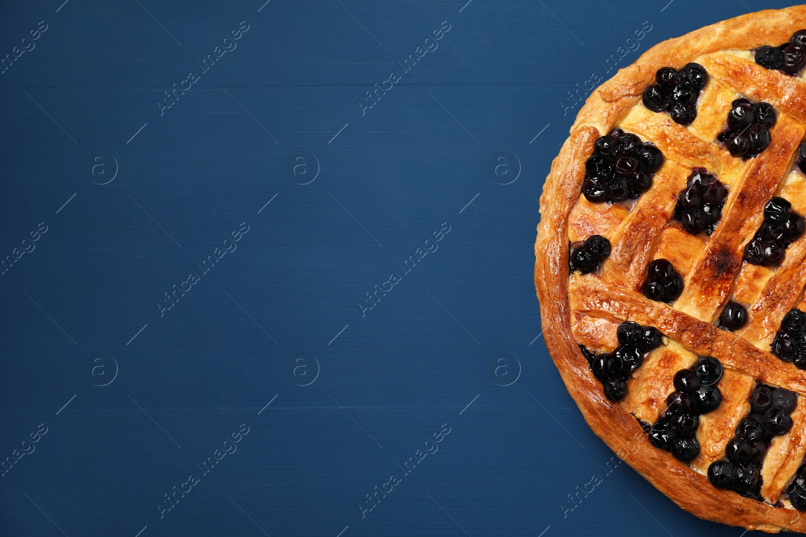 Photo of Tasty homemade pie with blueberries on blue wooden table, top view. Space for text