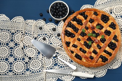 Photo of Tasty homemade pie with blueberries and mint served on blue wooden table, flat lay