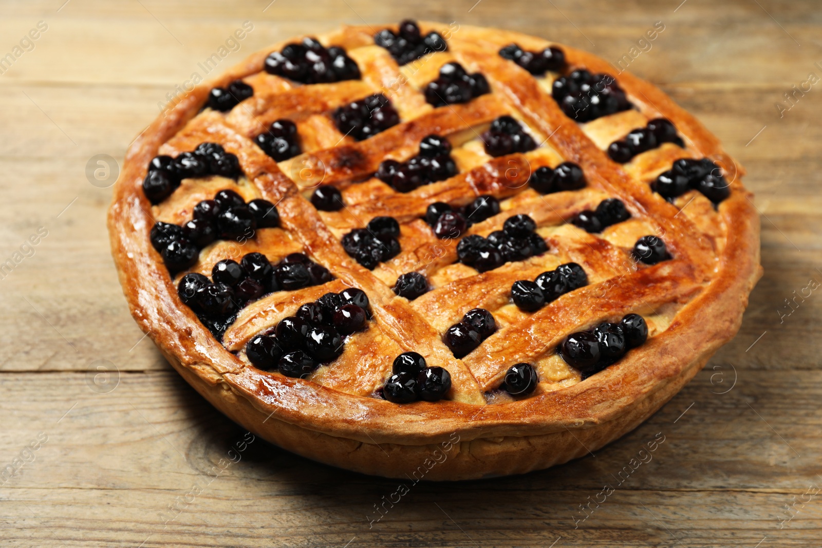 Photo of Tasty homemade pie with blueberries on wooden table, closeup