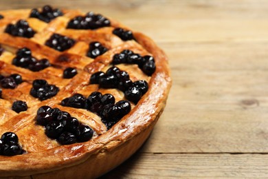 Photo of Tasty homemade pie with blueberries on wooden table, closeup. Space for text