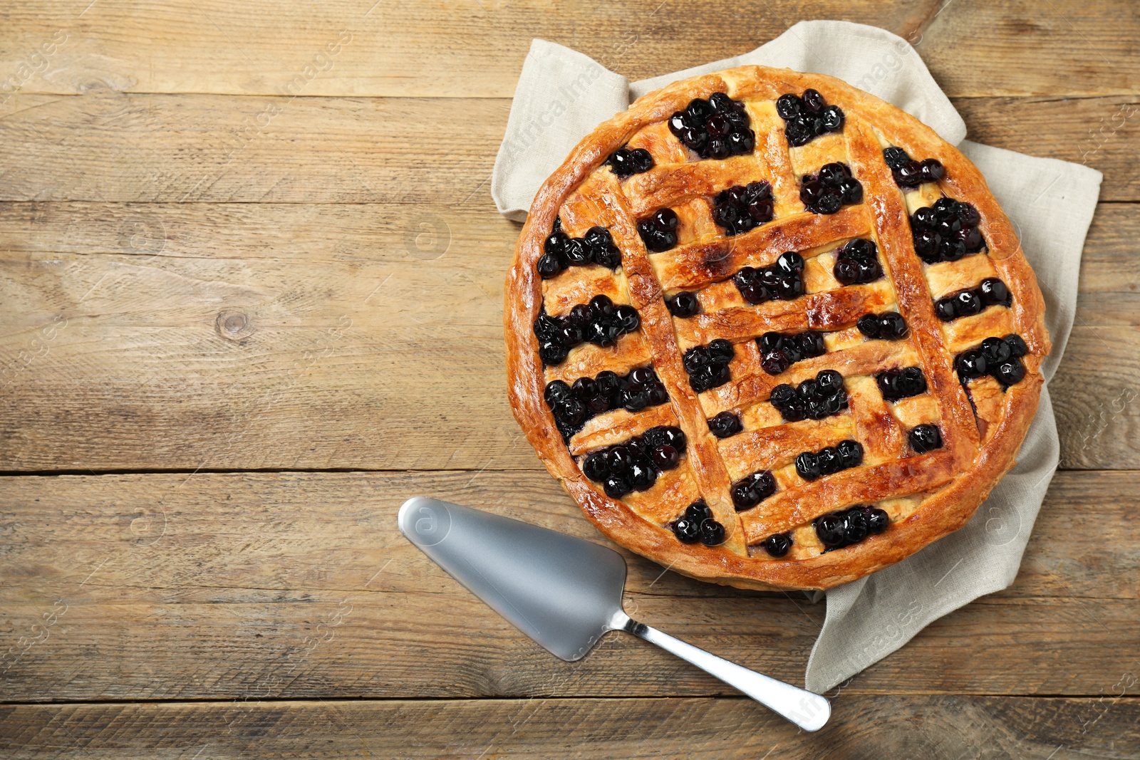 Photo of Tasty homemade pie with blueberries served on wooden table, flat lay. Space for text