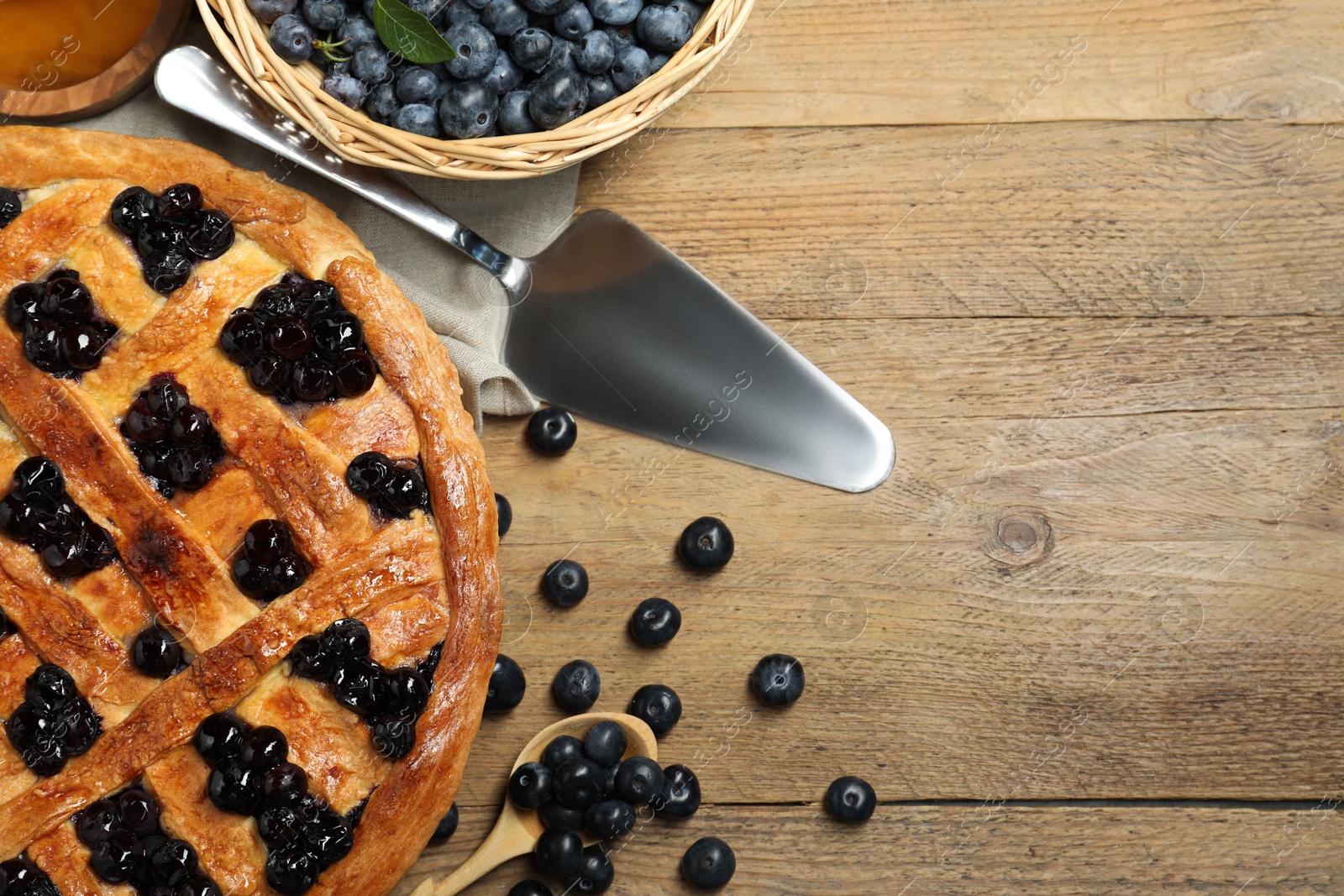 Photo of Tasty homemade pie with blueberries served on wooden table, flat lay. Space for text