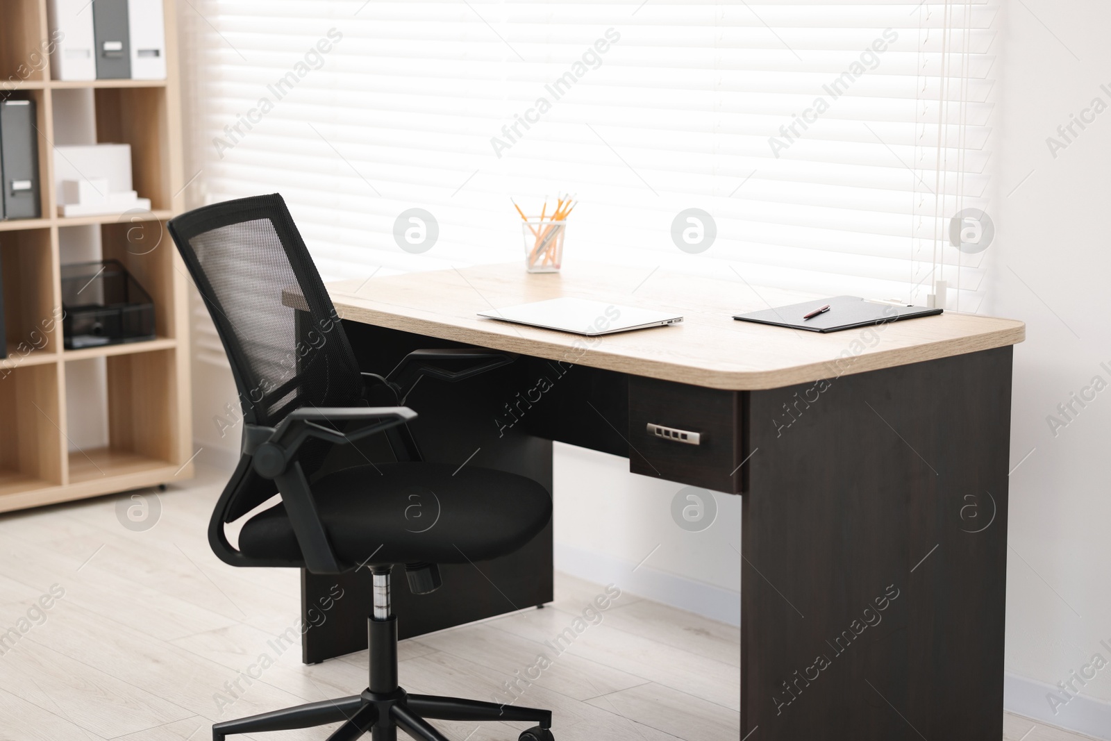 Photo of Black chair, laptop and desk in office