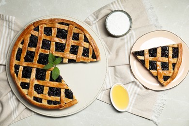 Tasty homemade pie with blueberries, honey and powdered sugar on gray textured table, flat lay