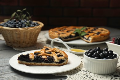 Piece of tasty homemade pie with blueberries on gray wooden table