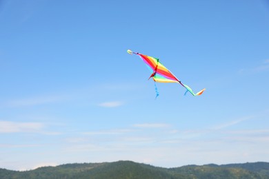 Photo of One colorful kite flying in blue sky