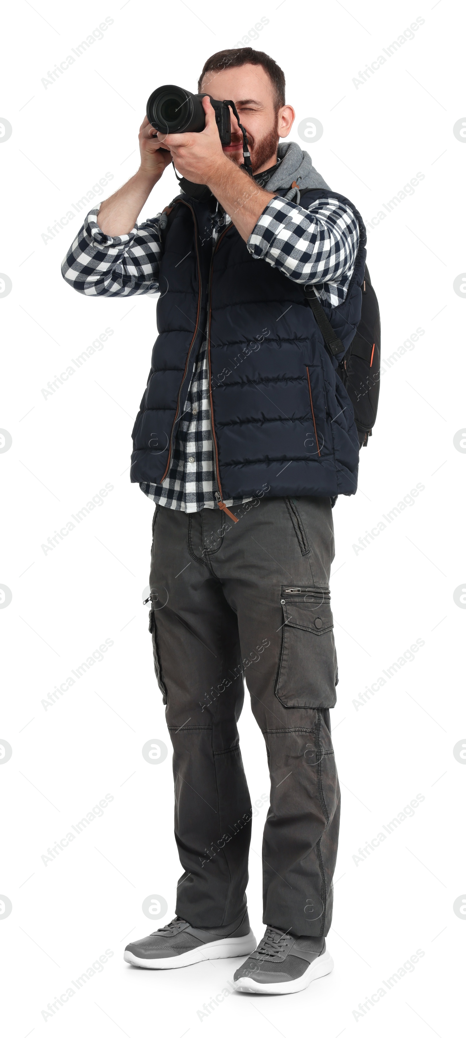 Photo of Photographer with backpack and camera taking picture on white background