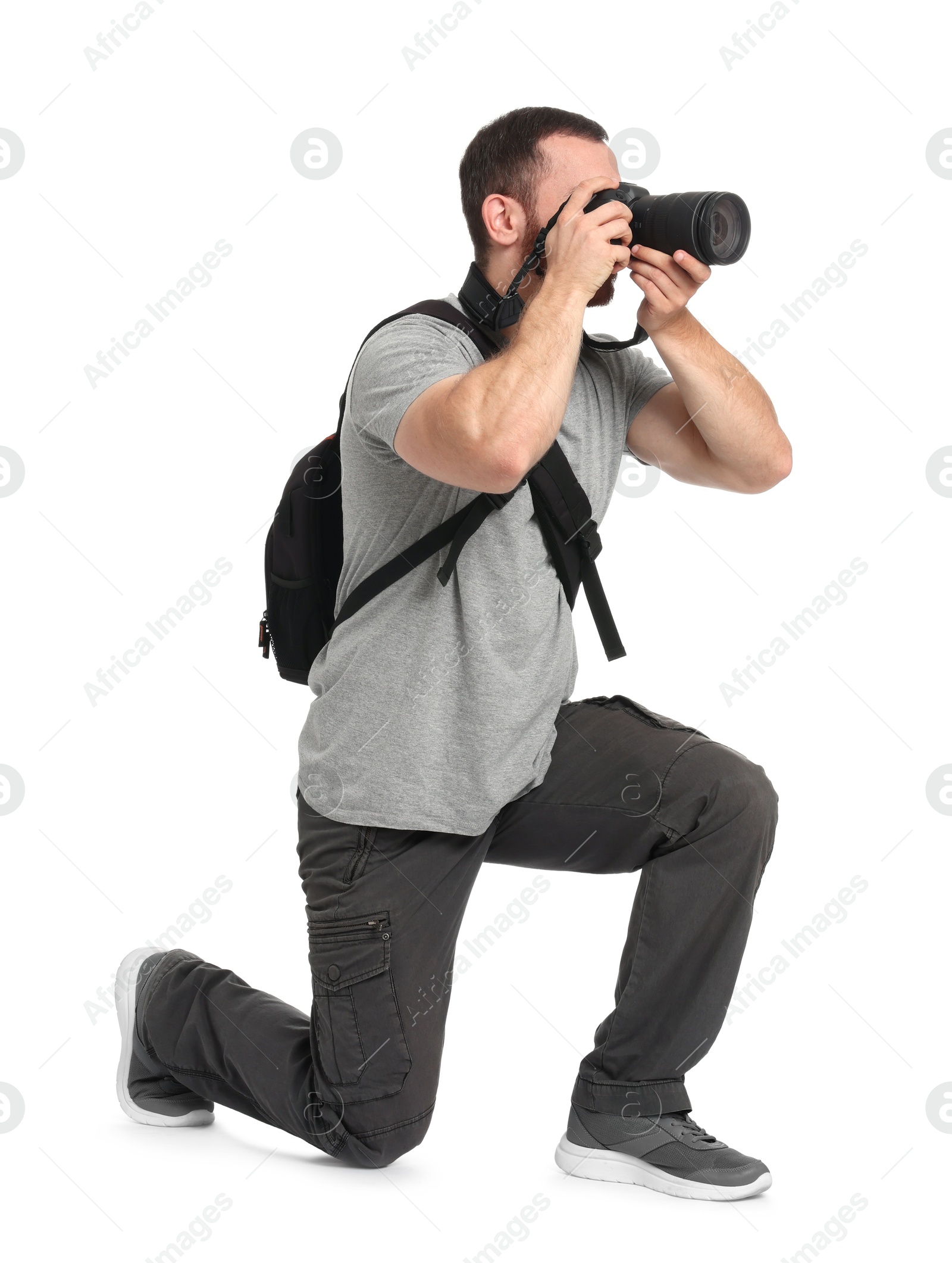 Photo of Photographer with backpack and camera taking picture on white background