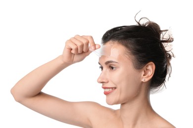 Photo of Smiling woman peeling off face mask on white background