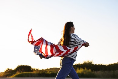 Photo of Woman with flag of USA running outdoors