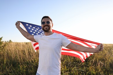 Photo of Happy man with flag of USA outdoors