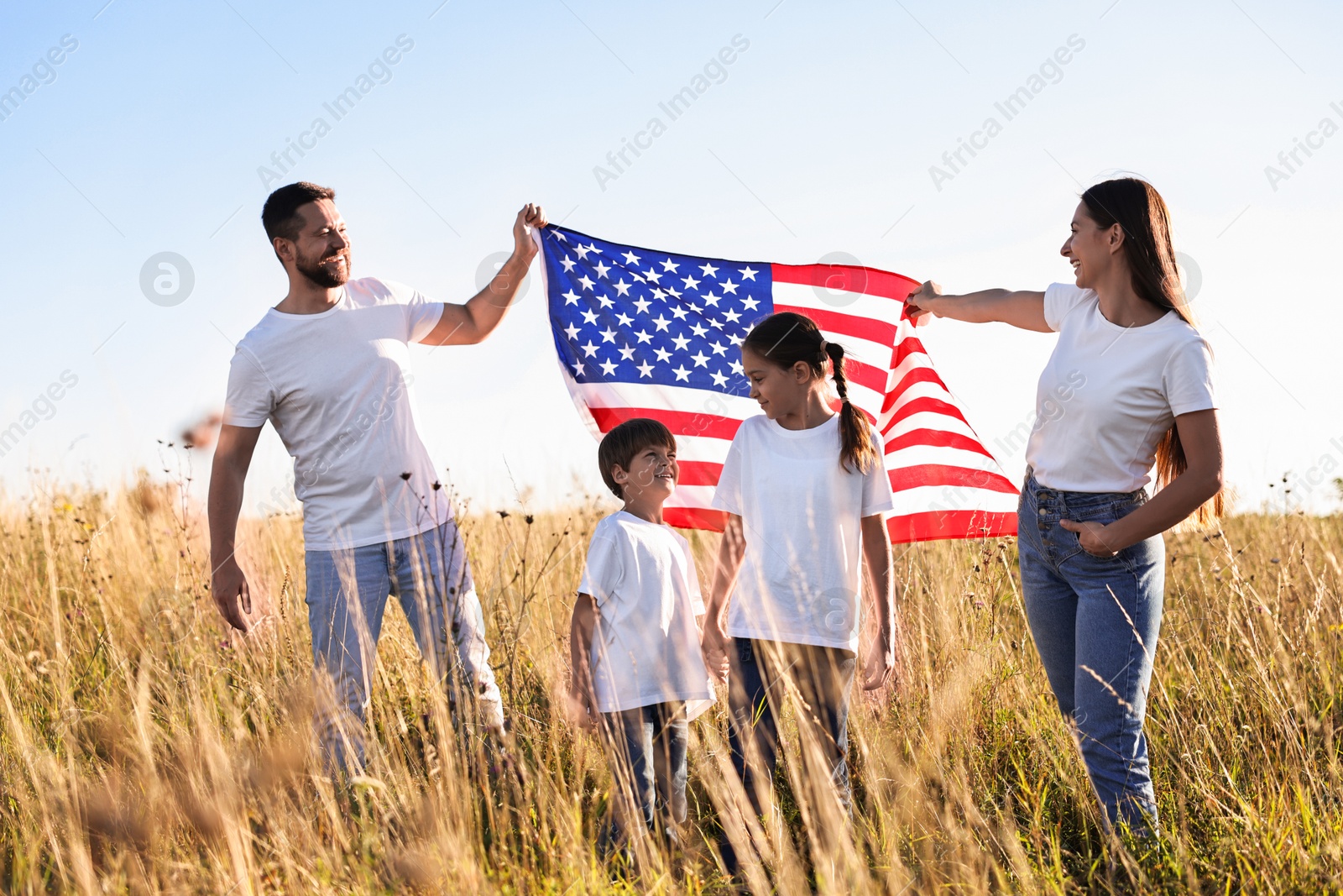 Photo of Happy family with flag of USA outdoors