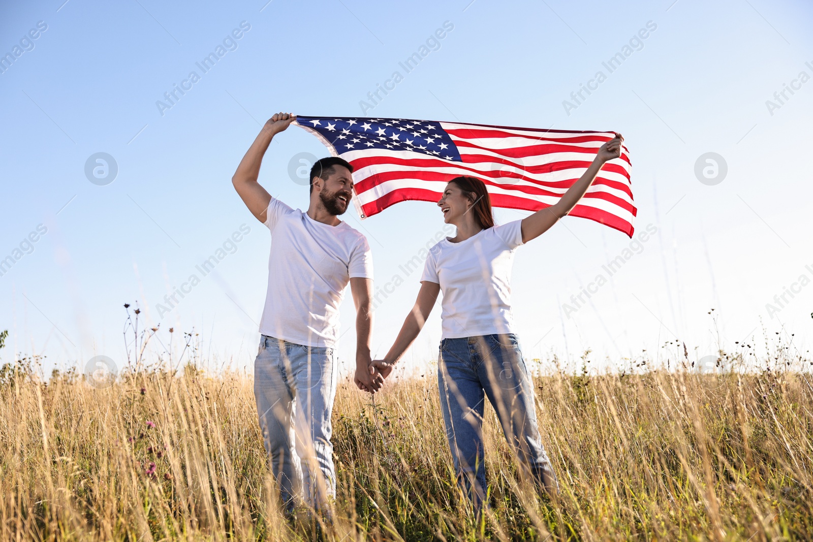 Photo of Happy couple with flag of USA outdoors