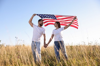 Happy couple with flag of USA outdoors