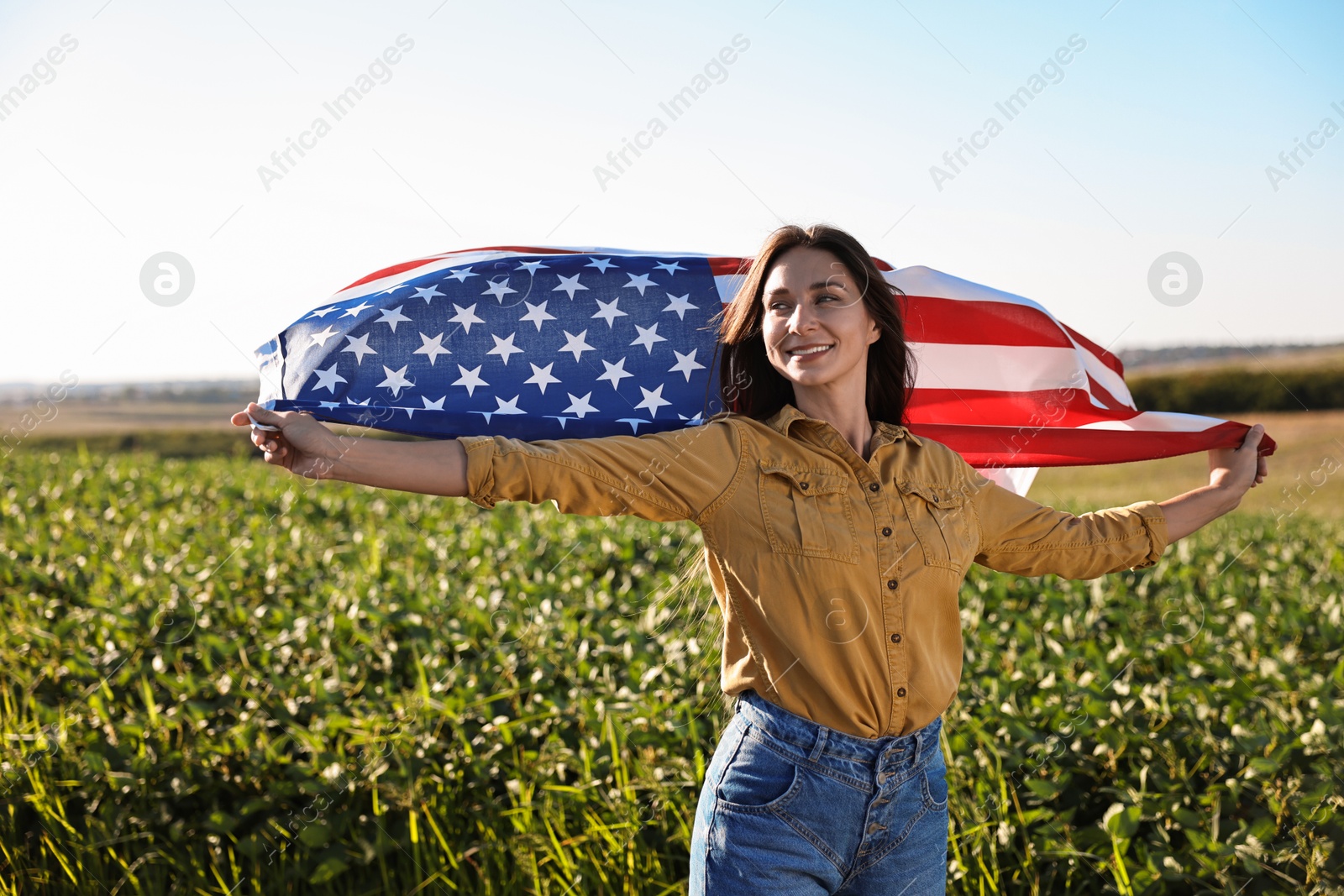 Photo of Happy woman with flag of USA outdoors