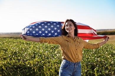 Happy woman with flag of USA outdoors