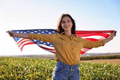 Happy woman with flag of USA outdoors