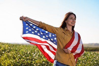 Photo of Happy woman with flag of USA outdoors