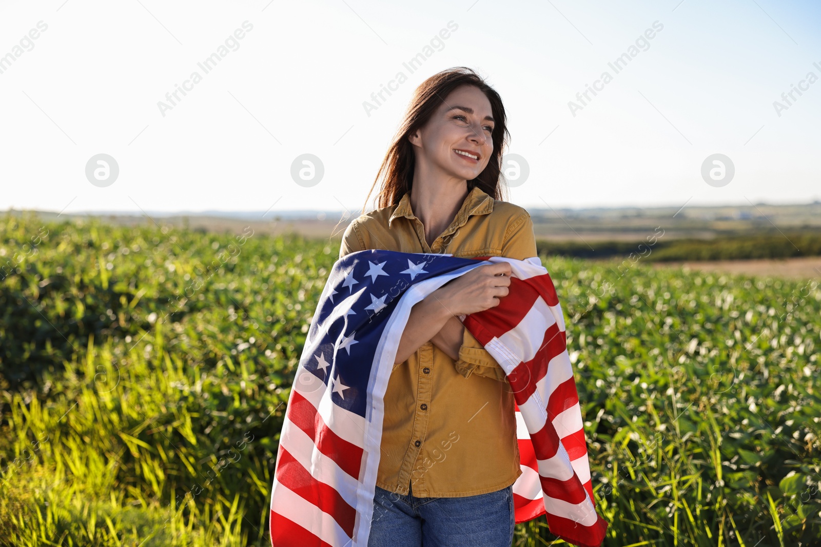 Photo of Happy woman with flag of USA outdoors