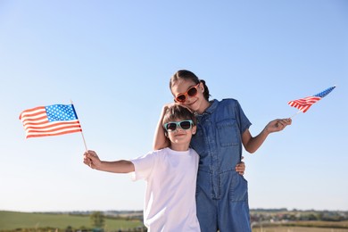 Photo of Brother and sister with flags of USA outdoors