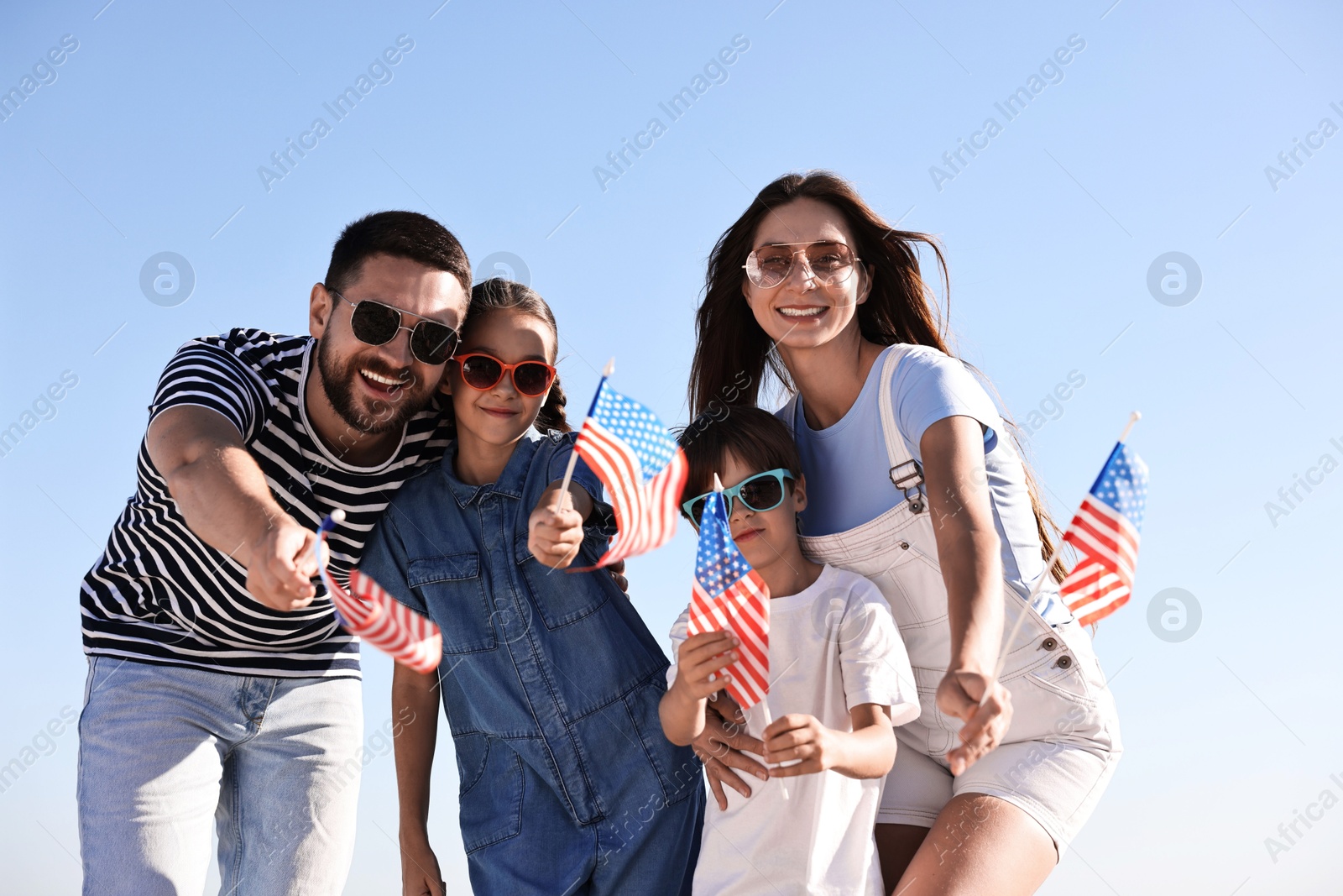 Photo of Happy family with flags of USA outdoors