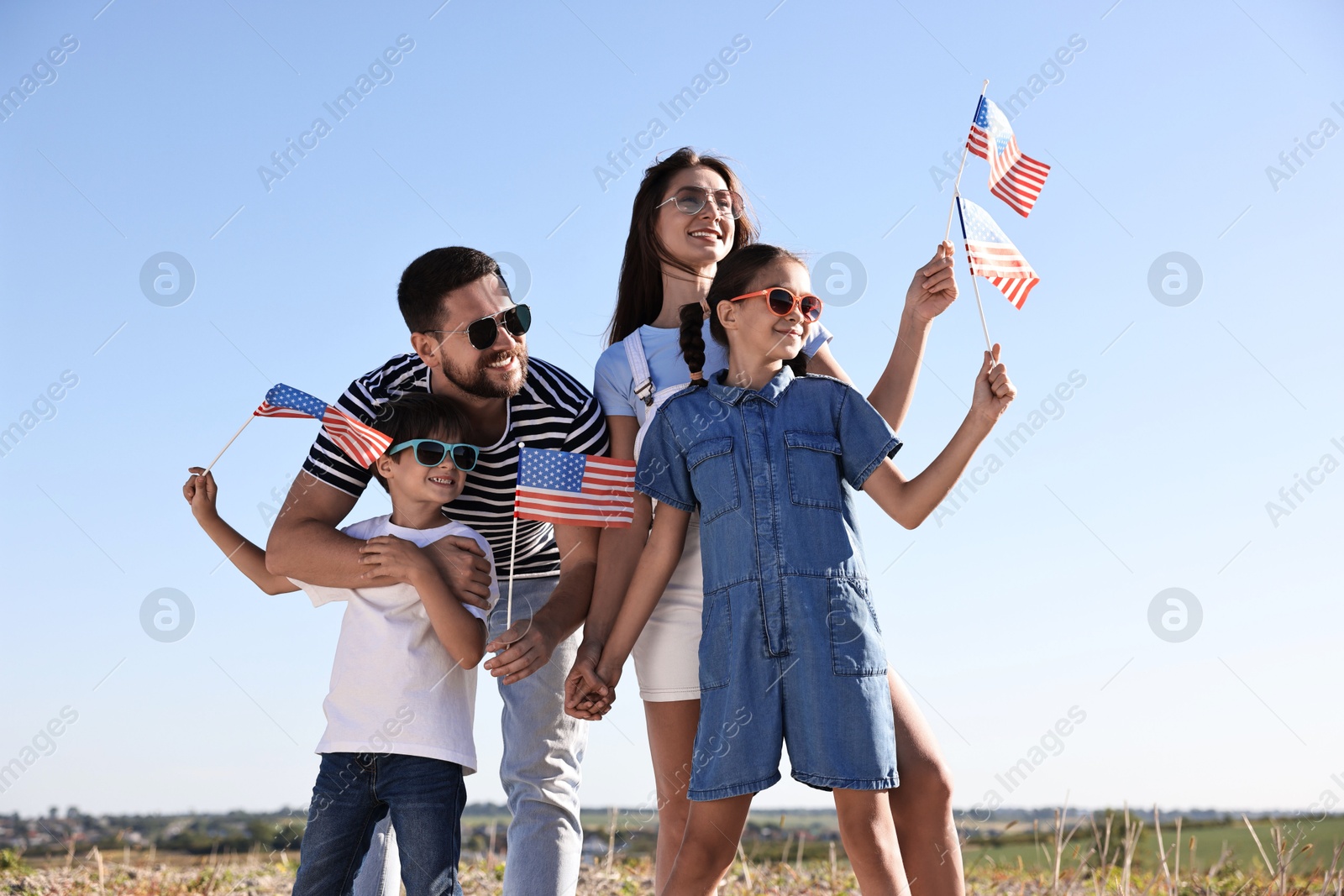 Photo of Happy family with flags of USA outdoors