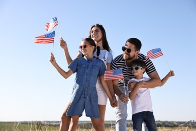 Photo of Happy family with flags of USA outdoors