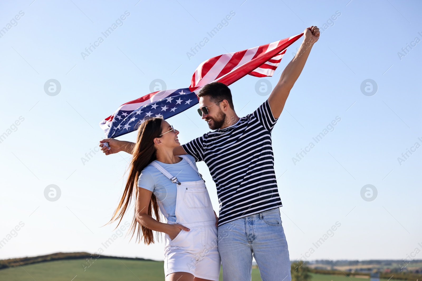 Photo of Happy couple with flag of USA outdoors