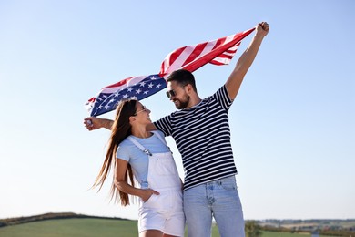 Photo of Happy couple with flag of USA outdoors